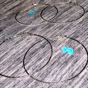 2 pair of silver hoop earrings , with aqua studs and baby blue flower earrings .